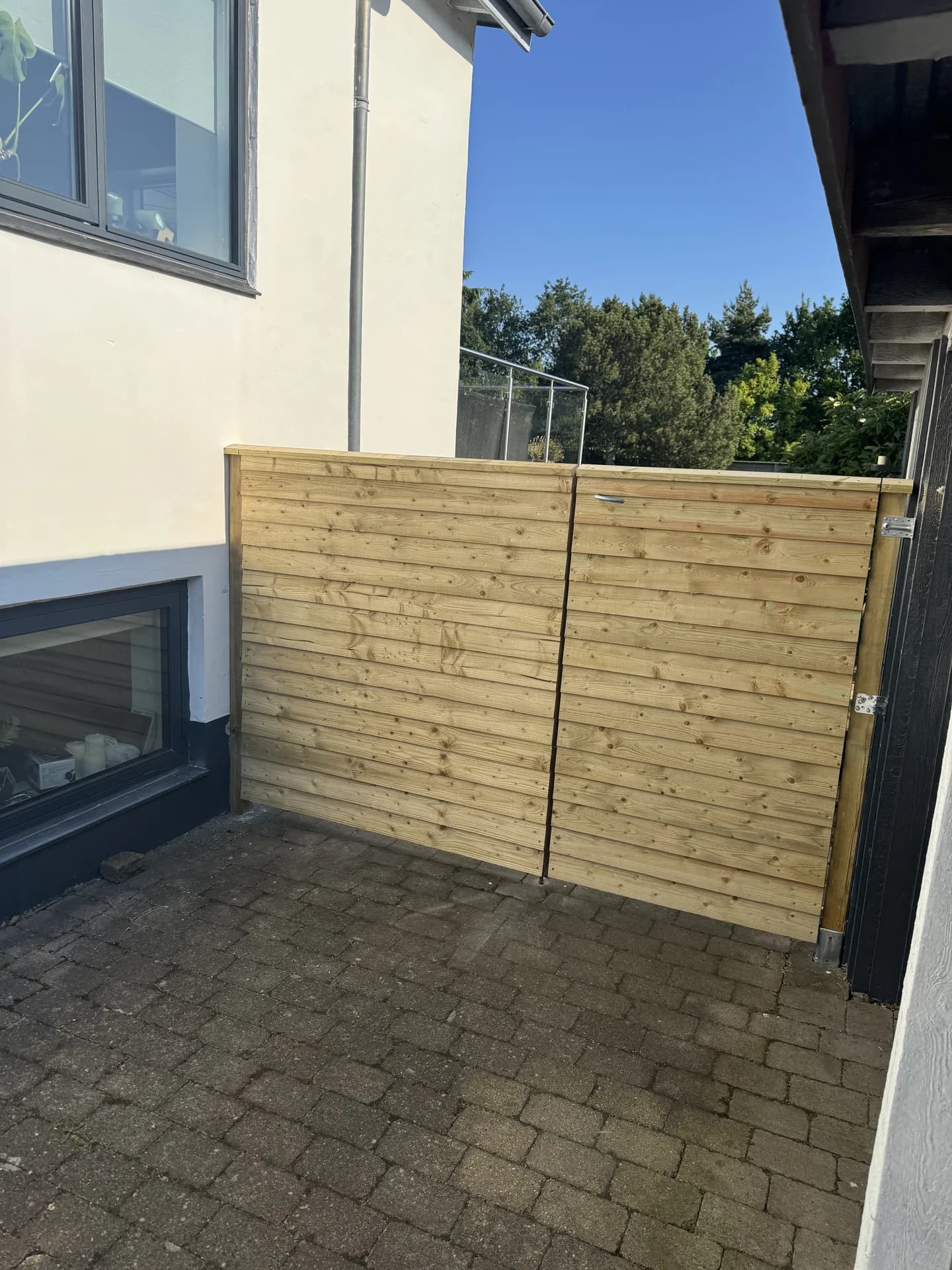 Træhegn og dobbeltlåge mellem hus og udbygning